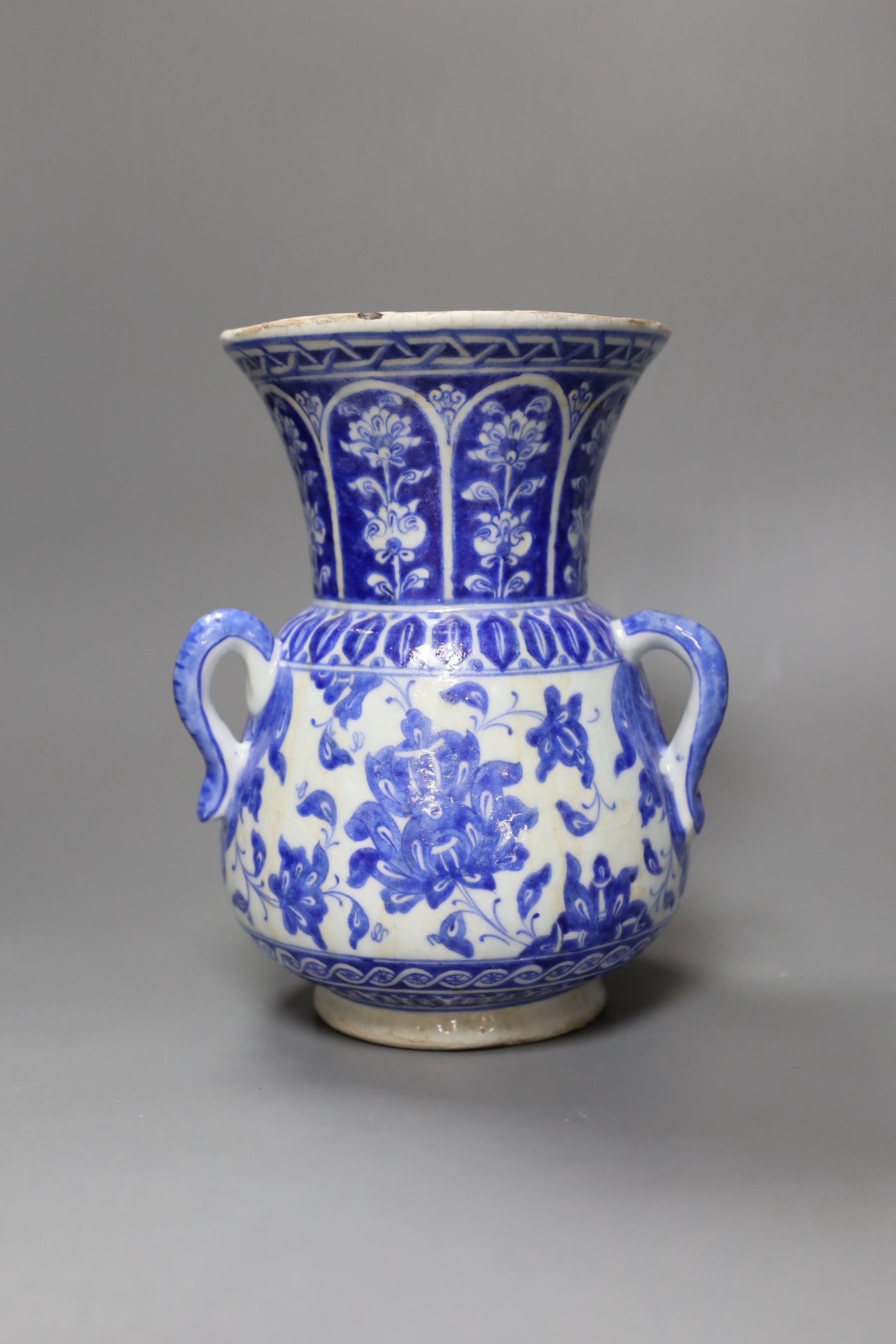 A three-handled blue and white Iznik pottery vase with floral motif, 22.5cm tall
